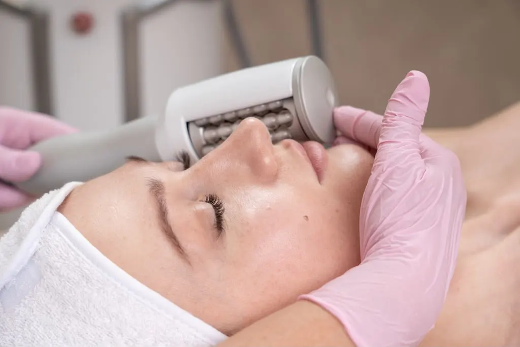A facial session with the roller head against the cheek